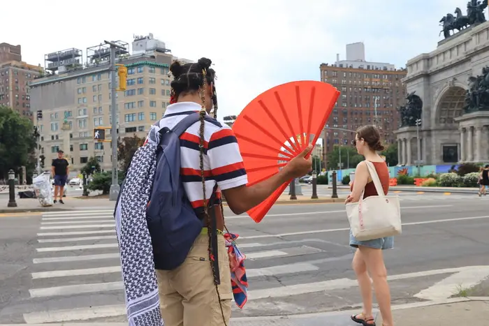 People prepare to cross the street near Grand Army Plaza in Brooklyn during hot weather on June 24, 2024.